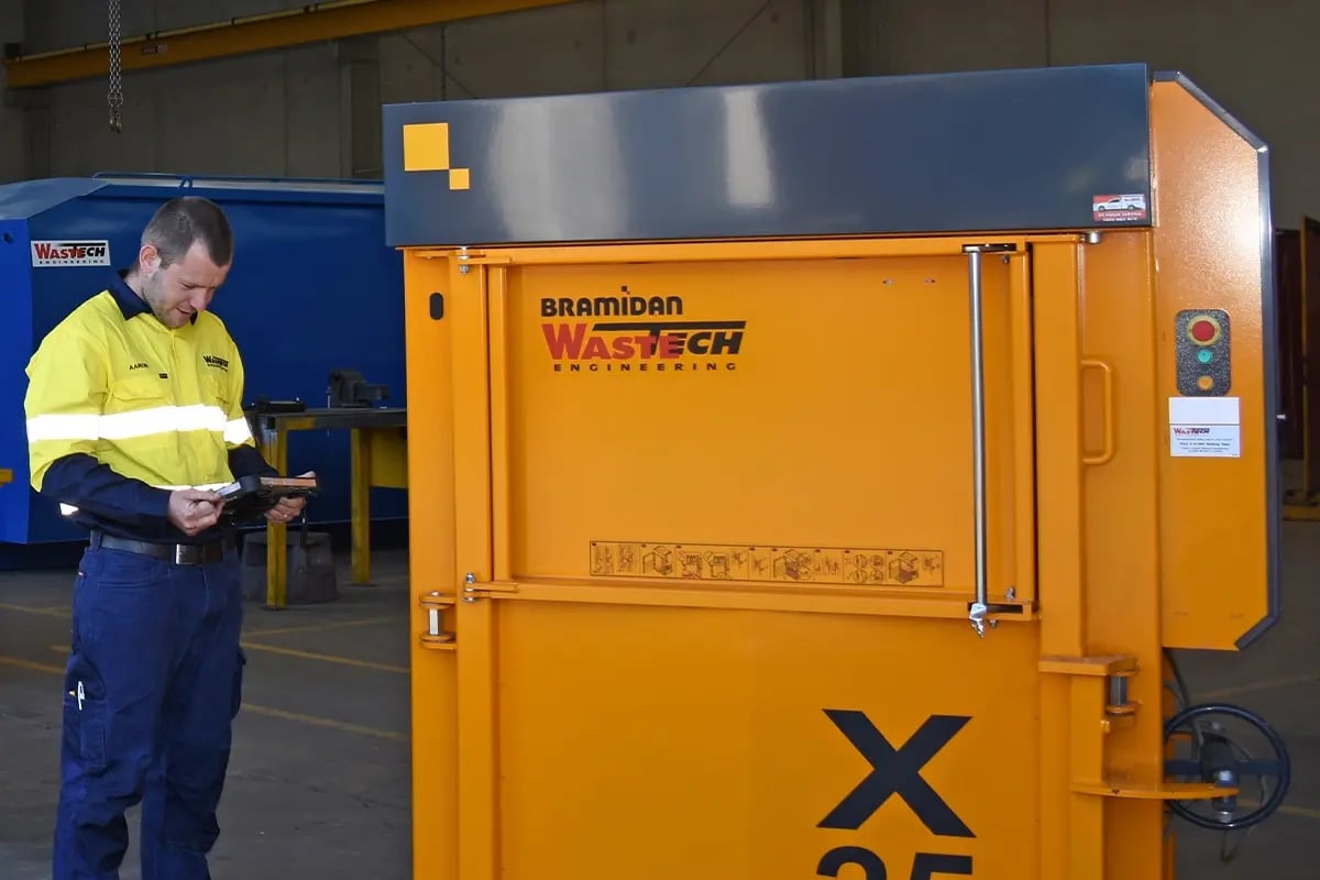 Wastech Engineering technician completing a Service and Compliance report after a scheduled preventative maintenance visit on waste equipment